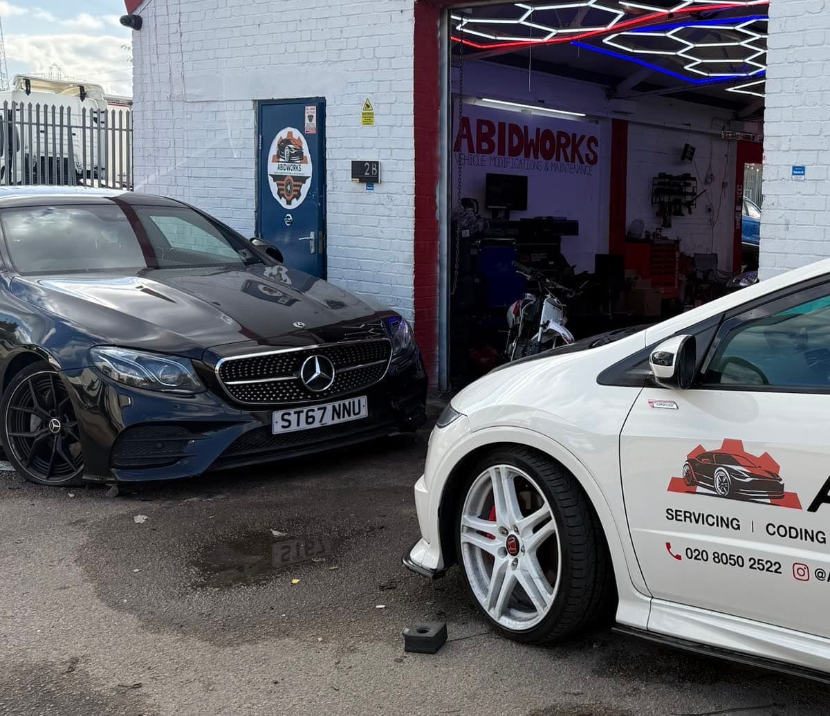 Mercedes-Benz E-Class and Honda Civic Type R outside the Abidworks workshop door