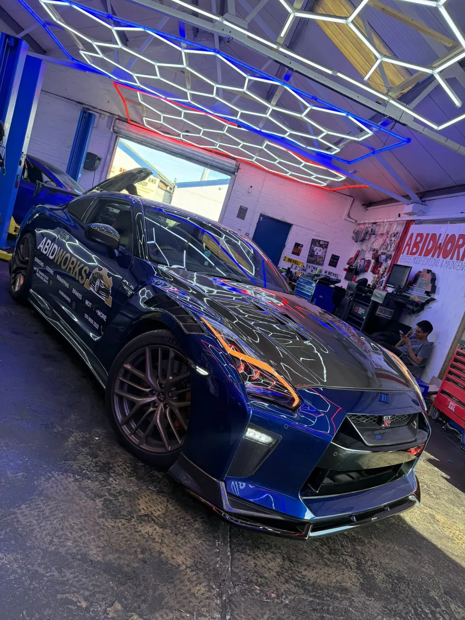 Blue Nissan GT-R in Abidworks livery in the workshop