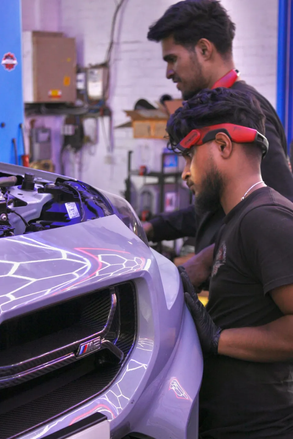 Two Abidworks technicians working on a BMW M2