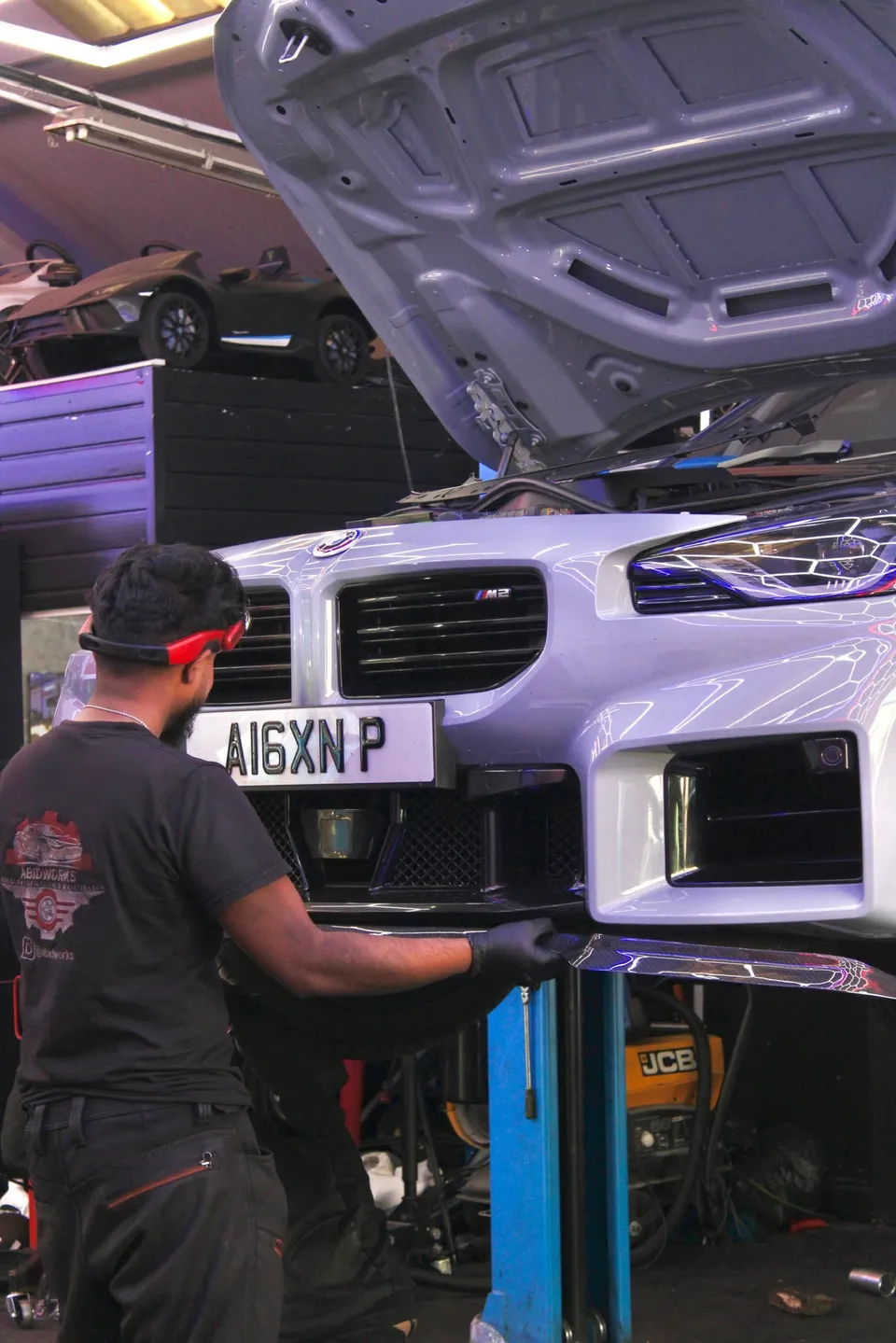 Technician working under the front of a BMW M2