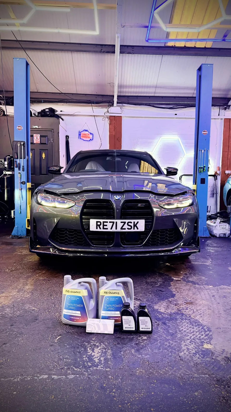 Grey BMW M3 on the ramp with oil and fluids ready