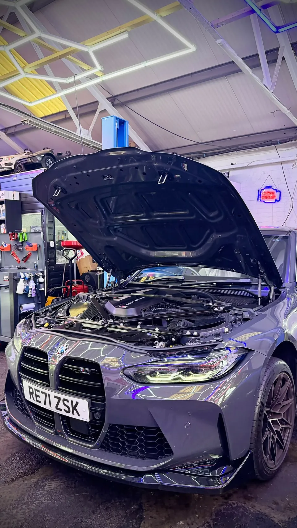 Grey BMW M3 with the bonnet up in the Abidworks workshop