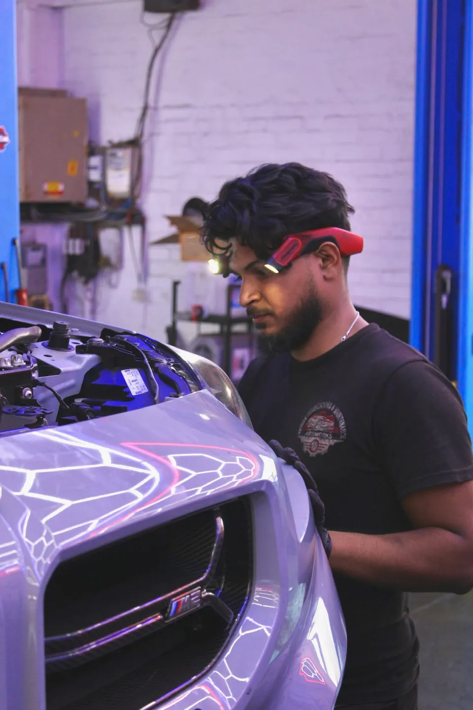 Technician working on the front of a BMW M2